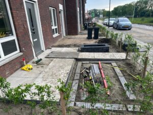 Stratenmaker Arnhem legt tegels van 50 cm bij 50 cm neer, voor het strakke gezicht